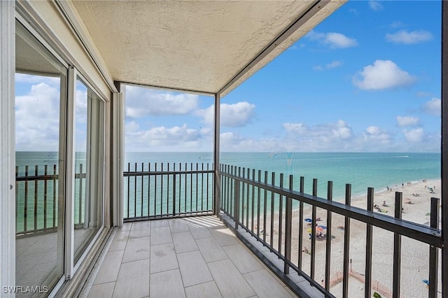 balcony with a water view and a beach view