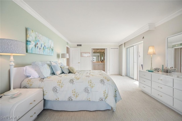 bedroom with visible vents, light colored carpet, ensuite bath, and crown molding