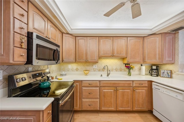 kitchen with ceiling fan, appliances with stainless steel finishes, sink, and backsplash