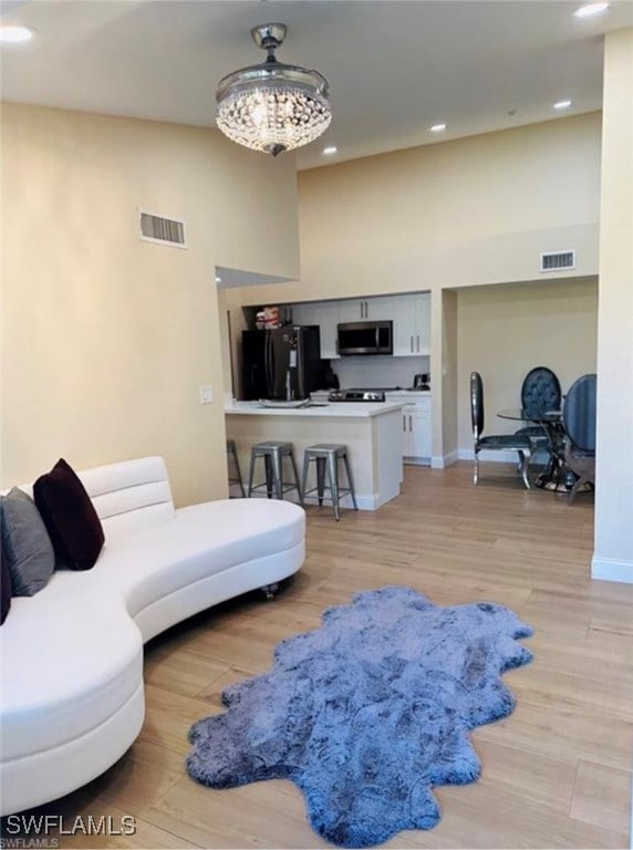 living room with light hardwood / wood-style flooring and a notable chandelier