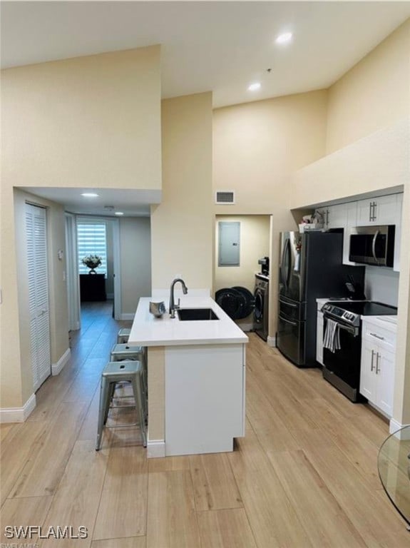 kitchen featuring light wood-type flooring, white cabinetry, stainless steel appliances, and sink