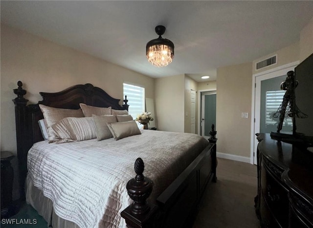 bedroom with an inviting chandelier and dark colored carpet