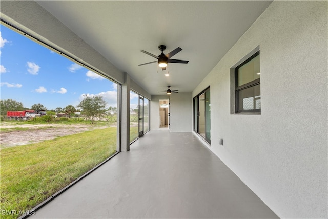 unfurnished sunroom featuring ceiling fan