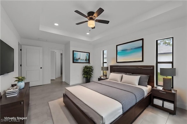 bedroom featuring ceiling fan and a tray ceiling