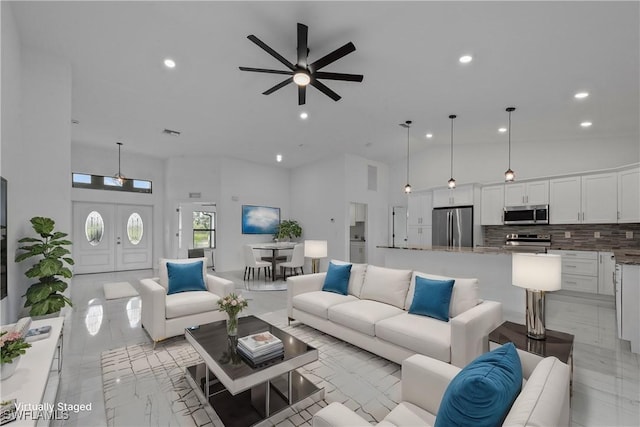 living room featuring a towering ceiling and ceiling fan