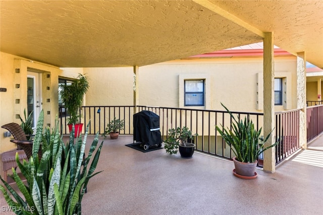 view of patio with area for grilling and a balcony