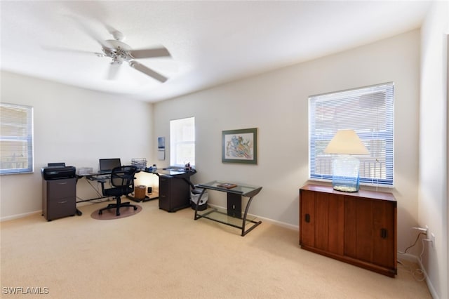 office with a healthy amount of sunlight, ceiling fan, and light carpet