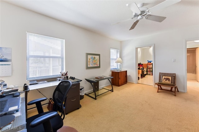 carpeted home office featuring ceiling fan