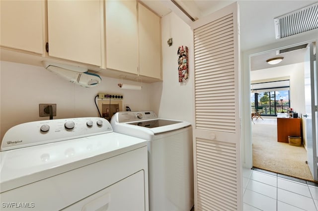 laundry room with separate washer and dryer, cabinets, and light tile patterned flooring