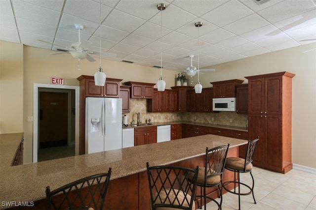 kitchen featuring ceiling fan, a breakfast bar area, and white appliances