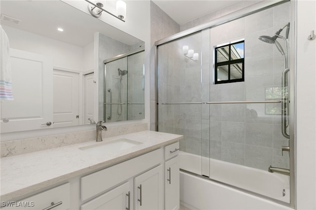 bathroom featuring vanity and shower / bath combination with glass door