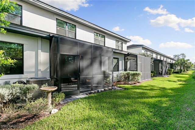 exterior space featuring cooling unit and a lawn