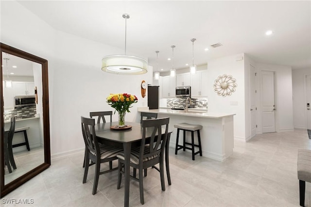 dining area with light tile patterned flooring and sink