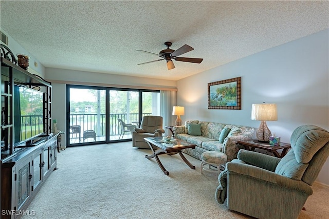living area featuring a ceiling fan, carpet flooring, and a textured ceiling