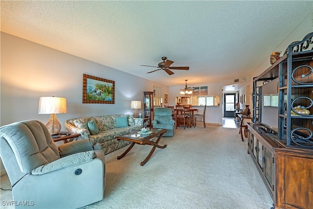 living room featuring carpet flooring, ceiling fan with notable chandelier, and a textured ceiling