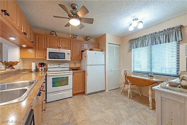kitchen featuring white appliances, a textured ceiling, a ceiling fan, light countertops, and baseboards