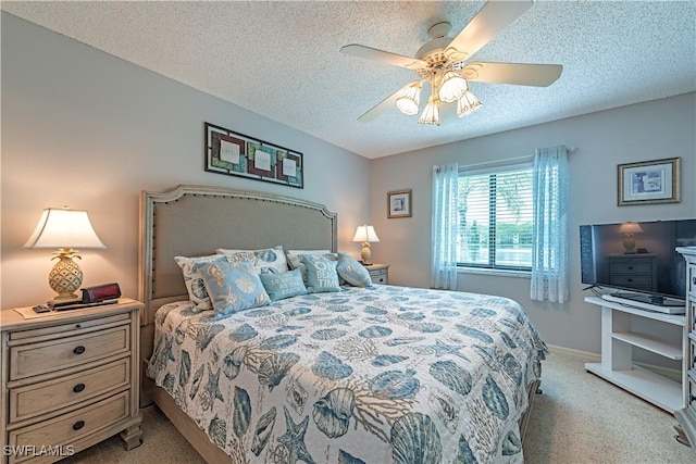 bedroom featuring baseboards, a ceiling fan, light carpet, and a textured ceiling