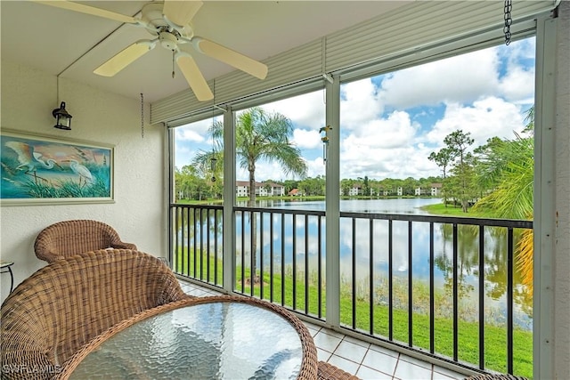 sunroom / solarium with a water view and a ceiling fan