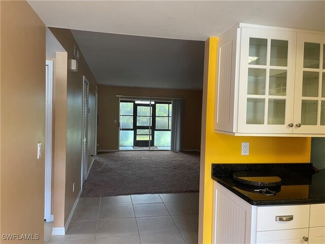 kitchen with white cabinets and dark colored carpet