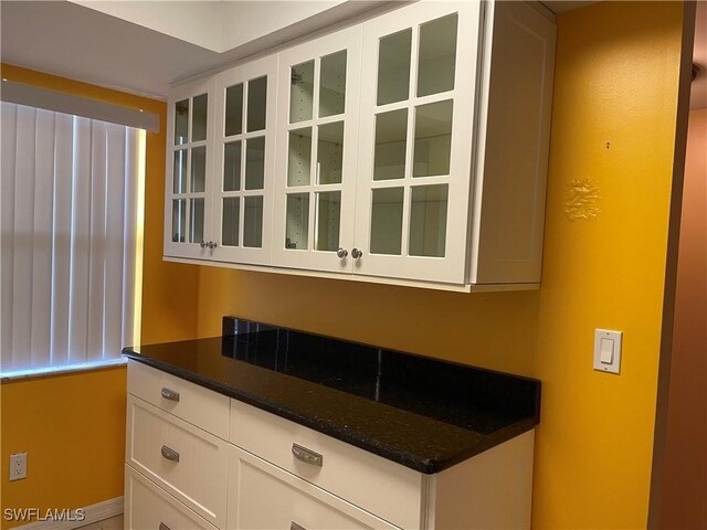 kitchen featuring white cabinets and dark stone countertops