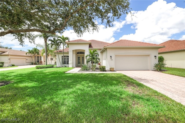 mediterranean / spanish-style house with a garage and a front lawn