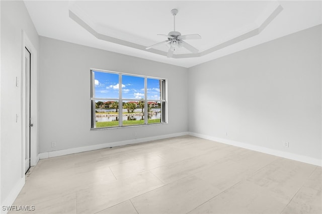 unfurnished room with a raised ceiling and ceiling fan