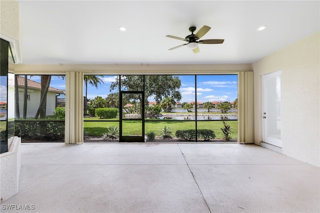 unfurnished sunroom with ceiling fan