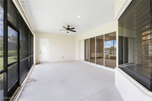 unfurnished sunroom with ceiling fan