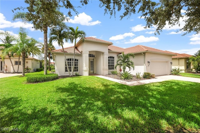 mediterranean / spanish-style house with a garage and a front lawn