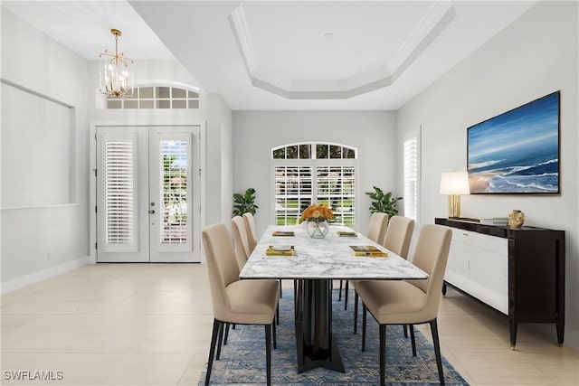 dining space with a notable chandelier, french doors, a tray ceiling, and ornamental molding