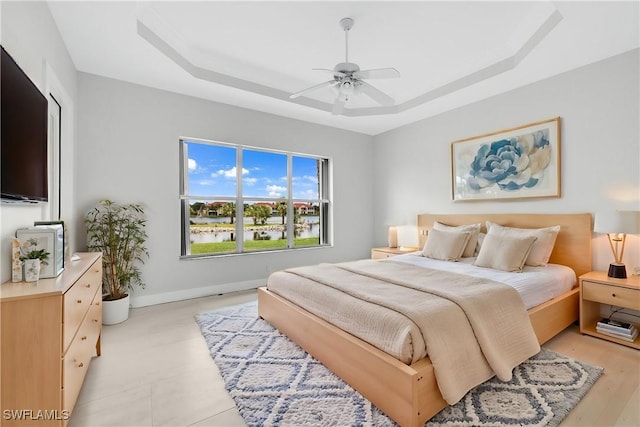 bedroom featuring ceiling fan and a tray ceiling