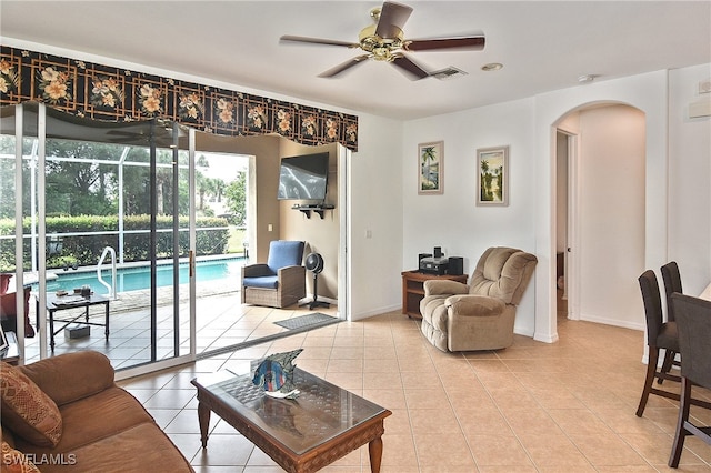 living room with a wealth of natural light, ceiling fan, and tile patterned flooring