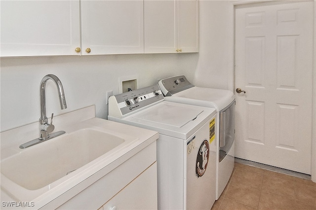 laundry area with separate washer and dryer, light tile patterned floors, cabinets, and sink