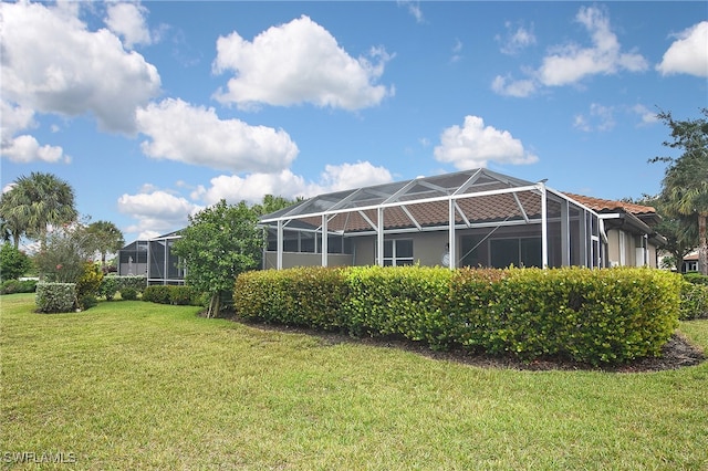 view of side of property featuring glass enclosure and a lawn