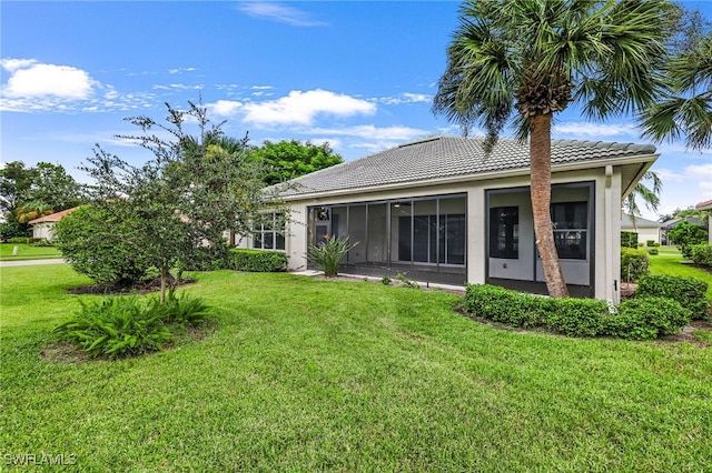 rear view of house with a sunroom and a lawn