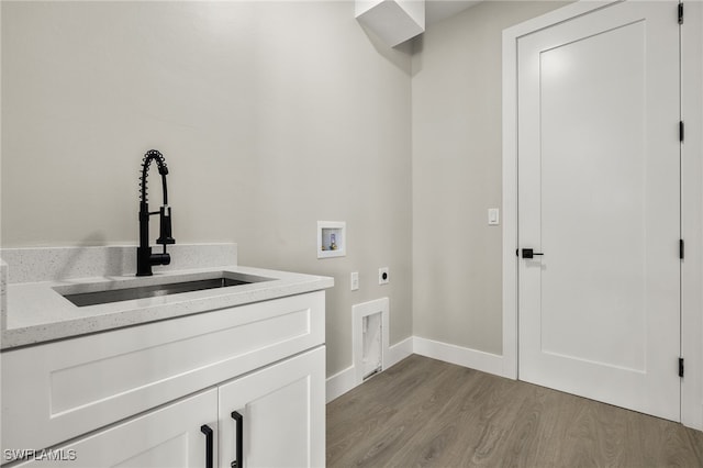 washroom with hookup for a washing machine, light hardwood / wood-style flooring, cabinets, sink, and electric dryer hookup