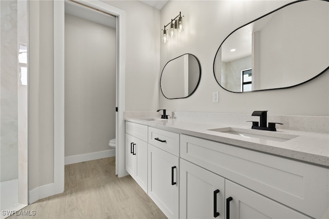 bathroom featuring vanity, toilet, and hardwood / wood-style floors