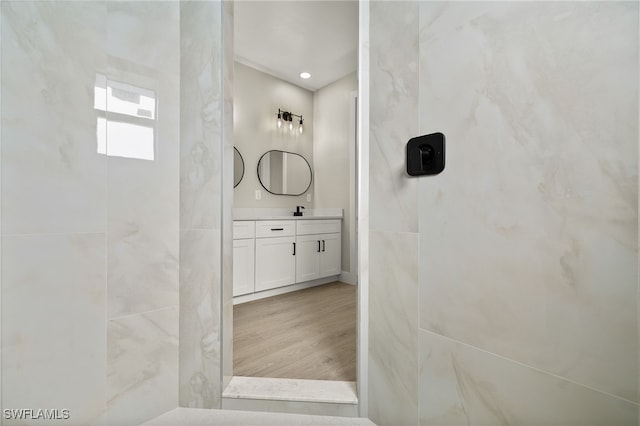 bathroom featuring vanity, a shower, and wood-type flooring