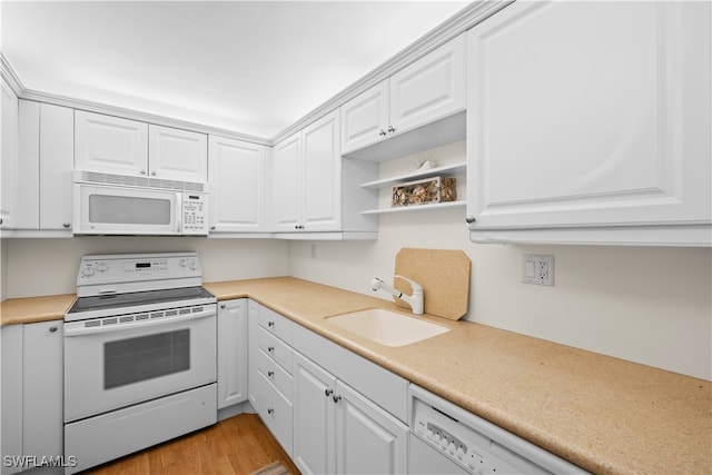 kitchen featuring light wood-type flooring, white cabinets, white appliances, and sink