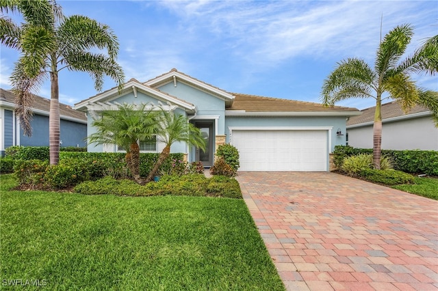 single story home featuring a front lawn, decorative driveway, an attached garage, and stucco siding