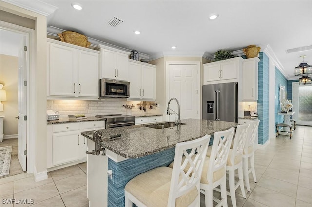 kitchen with stainless steel appliances, ornamental molding, light tile patterned flooring, and a sink