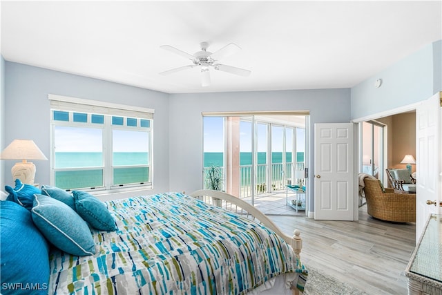 bedroom with access to outside, a water view, ceiling fan, and light hardwood / wood-style floors