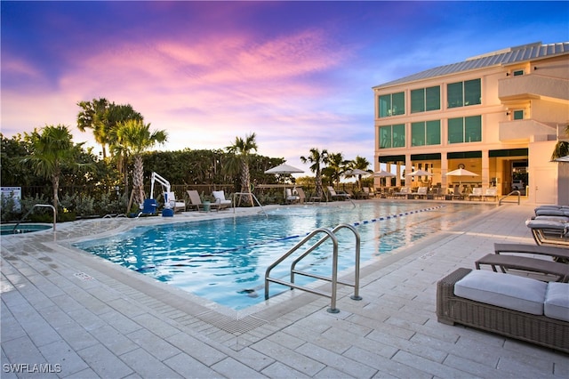 pool at dusk with a patio