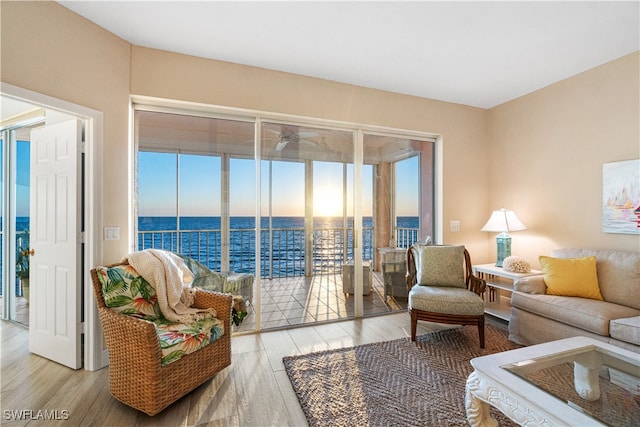 living room with light wood-type flooring and a water view