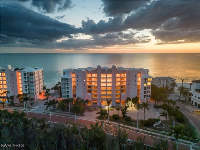 aerial view at dusk featuring a water view