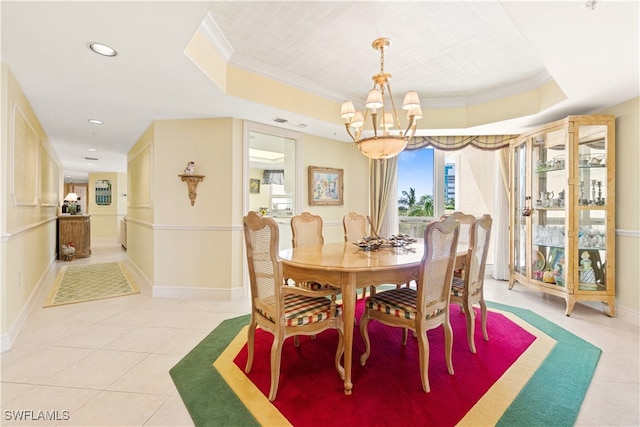 tiled dining room with ornamental molding, a chandelier, and a raised ceiling