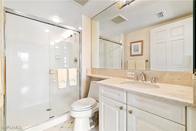 bathroom featuring a shower with door, vanity, and toilet