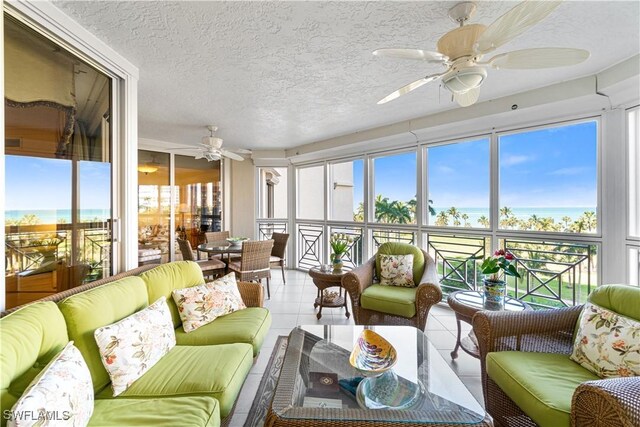 sunroom with a water view and ceiling fan