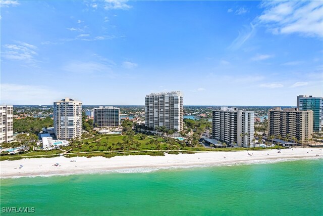 birds eye view of property with a water view and a beach view