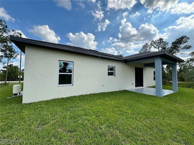 rear view of house featuring a patio area and a yard